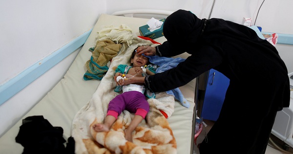 A woman helps her son as he lies on a bed at a cholera treatment center in Sanaa, Yemen, on June 6, 2017.