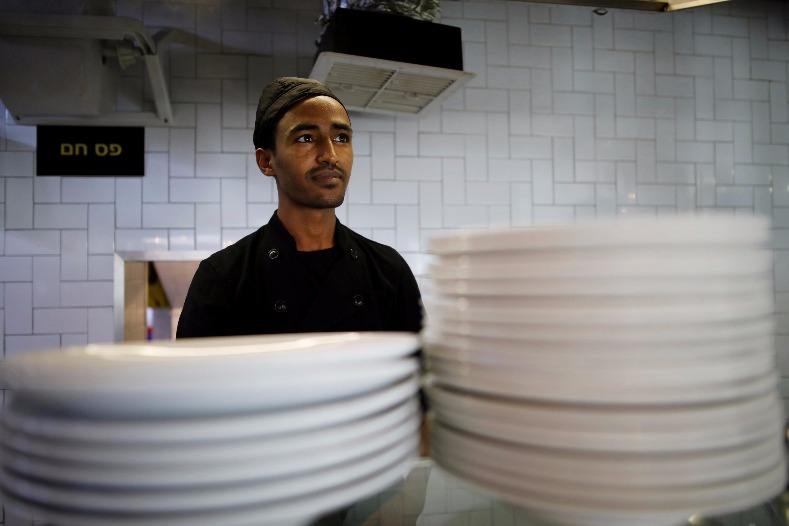Teklit Michael, 29, an asylum seeker from Eritrea, works in the kitchen of a restaurant in Tel Aviv, Israel June 25, 2017.