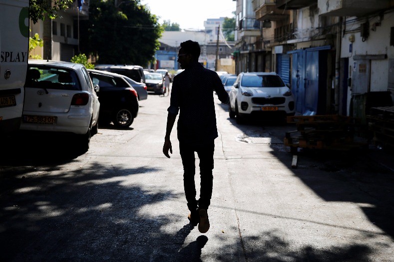 Teklit Michael, 29, an asylum seeker from Eritrea, is silhouetted as he walks home in Tel Aviv, Israel June 25, 2017. 