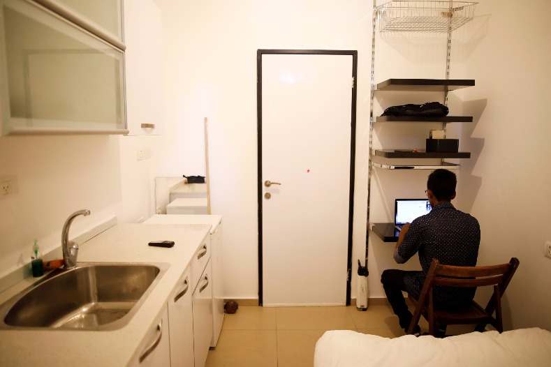 Teklit Michael, 29, an asylum seeker from Eritrea, works on his laptop at his home in south Tel Aviv, Israel June 25, 2017.