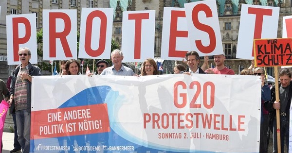 Protesters hold a banner in front of the townhall during a demonstration against the upcoming G20 summit in Hamburg.