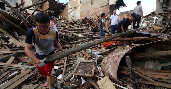 People remove debris at a collapsed house after a rainstorm in Lianyuan, Hunan province, China July 3, 2017.