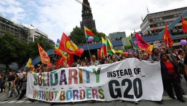People hold flags and banners during demonstrations at the G20 summit in Hamburg, Germany, July 8, 2017. 