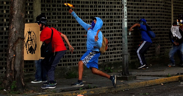 A protester throws a molotov cocktail during a protest against Venezuela's government in Caracas.