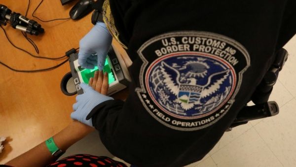 A woman who is seeking asylum has her fingerprints taken by a U.S. Customs and Border patrol officer at a pedestrian port of entry from Mexico to the United States, in McAllen, Texas, U.S., May 10, 2017.
