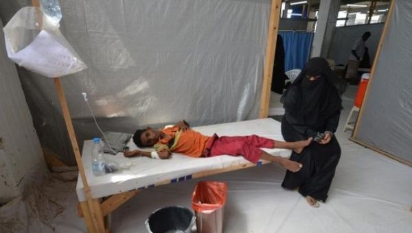 A woman sits next to a child infected with cholera in Yemen.