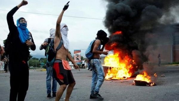 Opposition supporters shout as they burn tires during a protest.