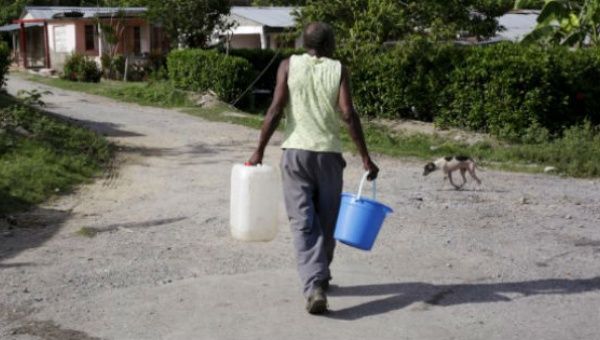 A man carries buckets of water while is searching a some of water at La Chusmita neighborhood in Consolacion del Sur, Pinar del Rio province, Cuba.