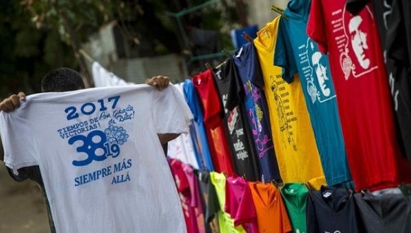 A child holds a T-Shirt commemorating the anniversary of the Sandinist Revolution in an improvised shop set up in the streets of Managua, Nicaragua.