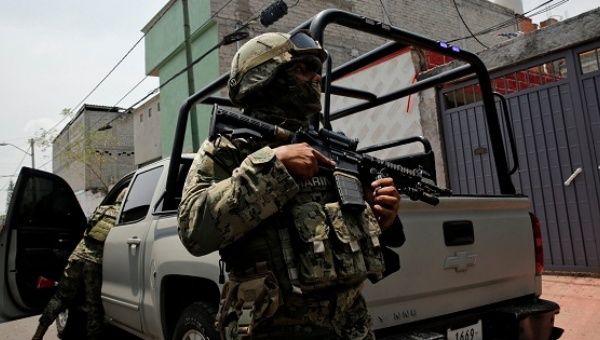 Mexican marine soldiers stand guard outside a house after suspected gang members were killed in a gun battle in Mexico City, Mexico, on July 21, 2017.