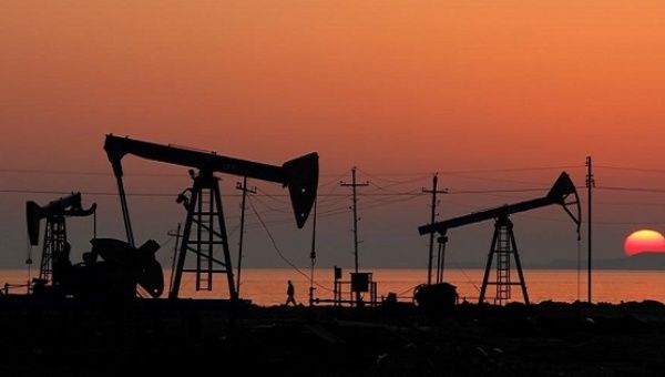 Pump jacks silhouetted against the rising sun on an oilfield in Baku, Azerbaijan.