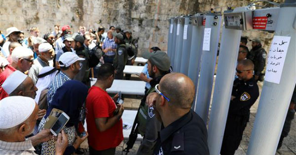 Palestinians stand in front of Israeli forces and newly-installed metal detectors at an entrance to the al-Aqsa Mosque  in the Old City of occupied East Jerusalem.
