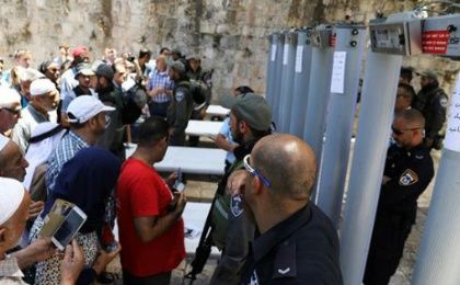 Palestinians stand in front of Israeli forces and newly-installed metal detectors at an entrance to the al-Aqsa Mosque  in the Old City of occupied East Jerusalem.