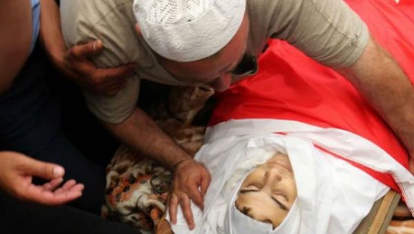 The father of 16-year-old Mohammed Jawawdah mourns over his son's body. Jawawdah was killed by an Israeli embassy guard in Amman, Jordan on Sunday. 