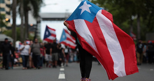 Protester wrapped in Puerto Rican flag.