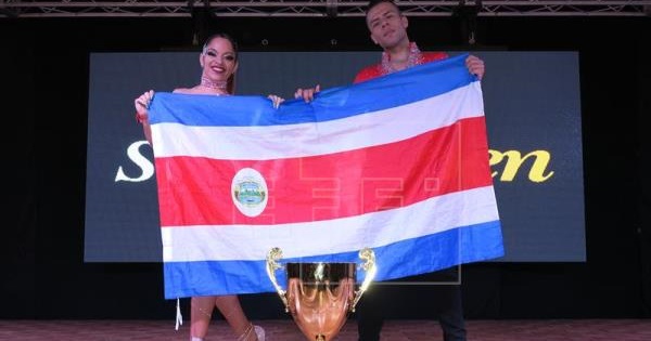The winning couple pose with their country's flag after winning the title, July 26, 2017, San Juan, Puerto Rico.