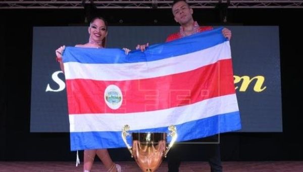The winning couple pose with their country's flag after winning the title, July 26, 2017, San Juan, Puerto Rico.