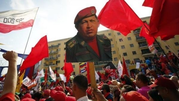 Supporters hold a poster of the late President Hugo Chavez.