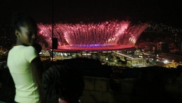 People watch fireworks from the Maracana Olympic Stadium during the opening ceremony, from the Mangueira favela.