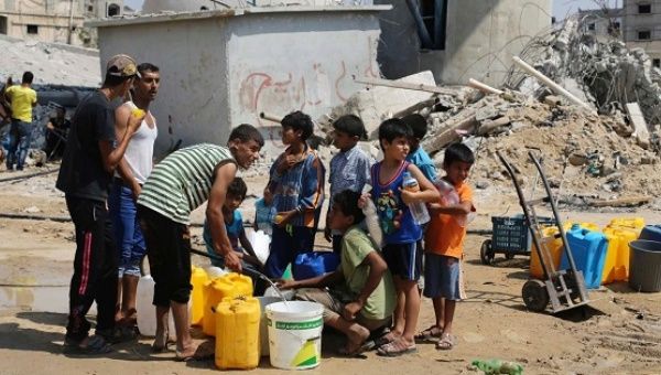 Palestinian children collect water in Khan Yunis, located in the southern Gaza Strip.