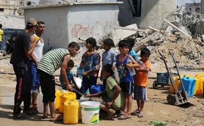 Palestinian children collect water in Khan Yunis, located in the southern Gaza Strip.