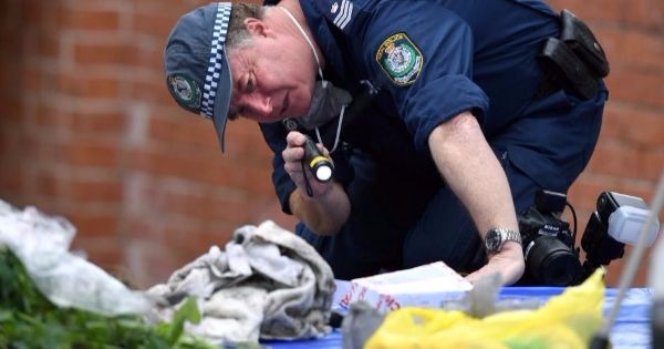 A police officer searches items seized during a raid.