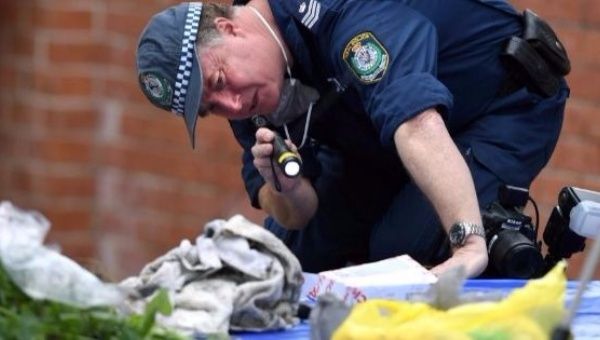 A police officer searches items seized during a raid.