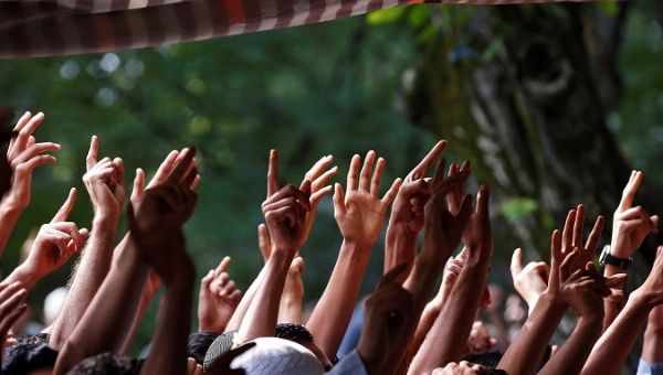 People raise their arms while shouting pro-freedom slogans as the body of Zahid Ahmad Bhat, a Kashmiri rebel, was killed by Indian security forces, August 10, 2017.