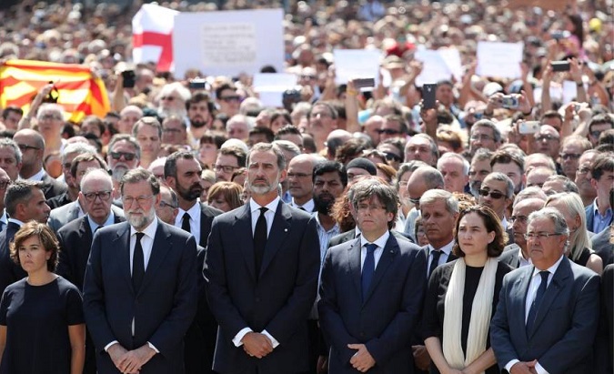 Spain's King stands at the front of a crowd giving a minute of silence for victims of yesterday's deadly attack in Catalonia.