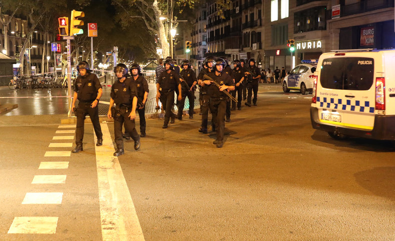 Armed Catalonian police officers leave the site of Thursday's attack in Las Ramblas