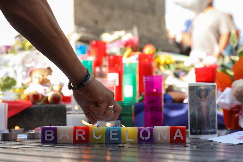 A man lights a candle at a vigil in Barcelona as people gathered near the site to pay their respects