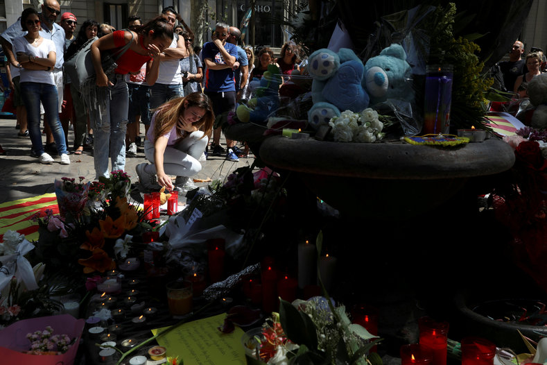 A woman reacts at the memorial for victims of the attack in Barcelona