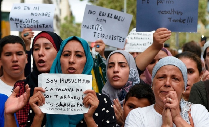 Muslim residents of Barcelona hold messages reading 'I am a Muslim Catalan, I am not a terrorist. Islam is peace' and 'We are also afraid' as they demonstrate.