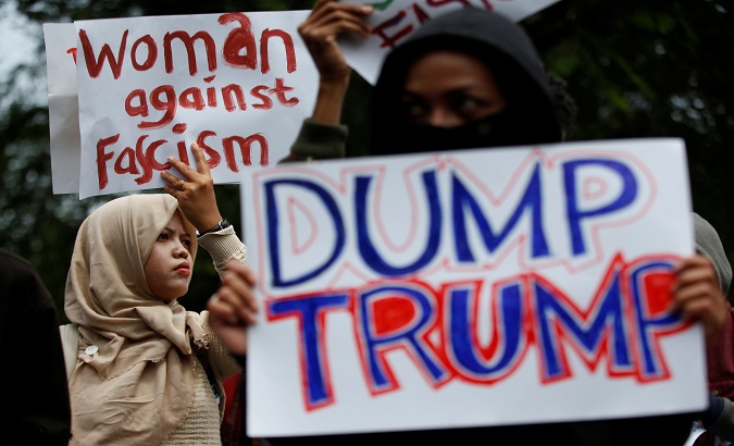 Activist hold placards as they protest against U.S. President Donald Trump’s recent policies, outside the U.S. embassy in Jakarta, Indonesia, Feb. 4, 2017.