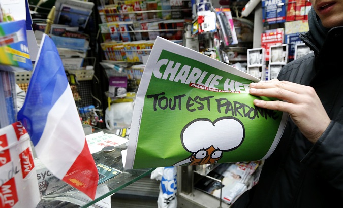 A man holds a 2015 issue of satirical French weekly Charlie Hebdo entitled 