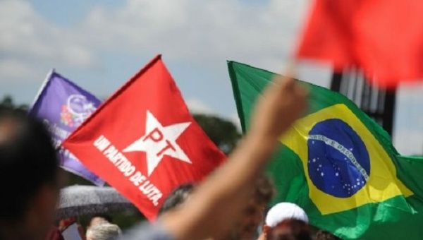 Protesters wave Workers Party and National flags during a demonstration against unelected president Michel Temer.