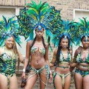 Costumed masqueraders pose before taking to the streets as part of Notting Hill Carnival.