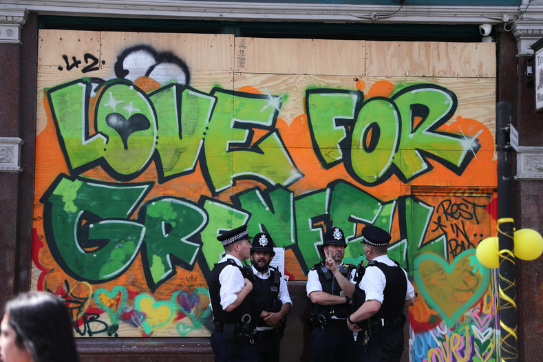 Met police chatting by a wall graffitied with a message of support for the victims of Grenfell. Grime artist Stormzy had criticized the Met for linking drug raids to Notting Hill, while they've rarely done so for Glastonbury.