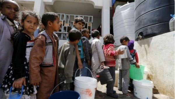 Children stand in line for water at a school in Sanaa, Yemen