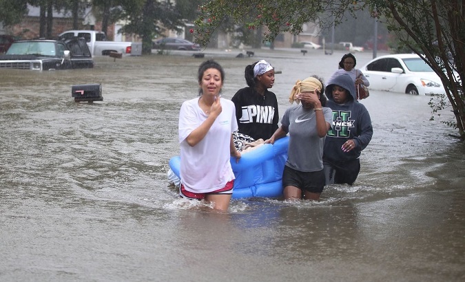 Houston residents trudge through floodwaters.