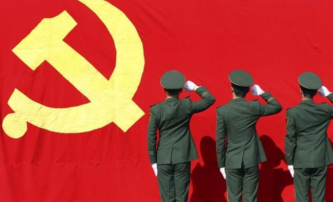 Paramilitary police raise fists to the Communist Party of China flag ahead of a National Congress.