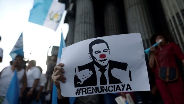 A demonstrator holds a sign as he protests against Guatemalan President Jimmy Morales in front of the National Palace in Guatemala City.