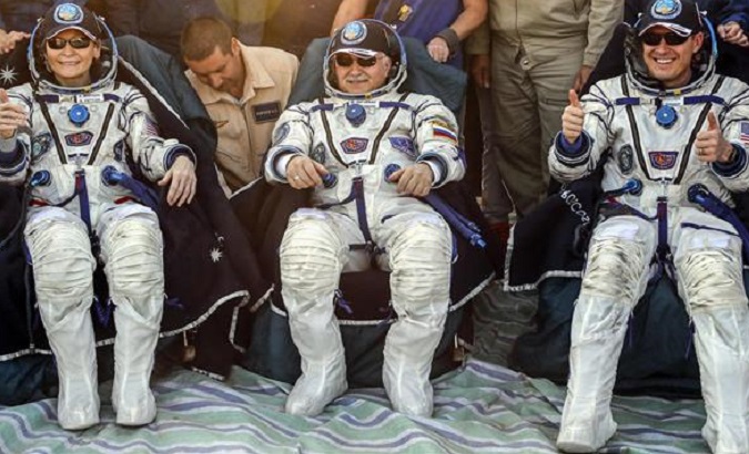 Russian cosmonaut Fyodor Yurchikhin (C), U.S. astronauts Jack Fischer (R) and Peggy Whitson pose shortly after landing in Kazakhstan, Sept. 3, 2017.