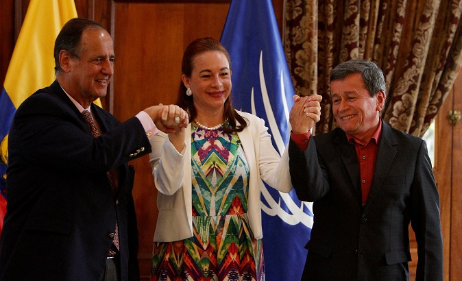 Restrepo (L), delegate of the Colombian government, Ecuador's FM Espinosa (C) and Beltran, representative of ELN, hold hands in Quito, Ecuador.