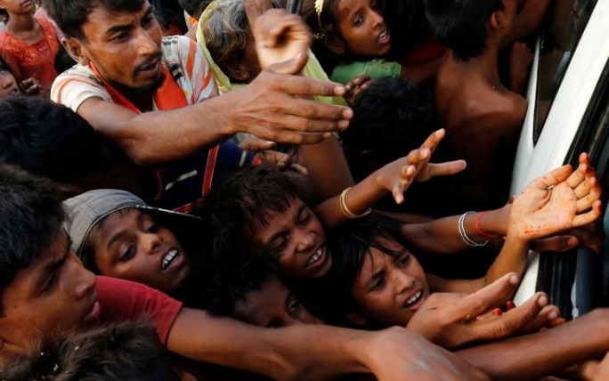 Rohingya refugees stretch their hands for food near Balukhali in Cox’s Bazar, Bangladesh, September 4, 2017.