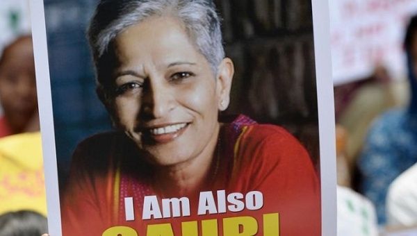 A protester holds a sign with journalist Gauri Lankesh at a rally following her murder on Tuesday night.