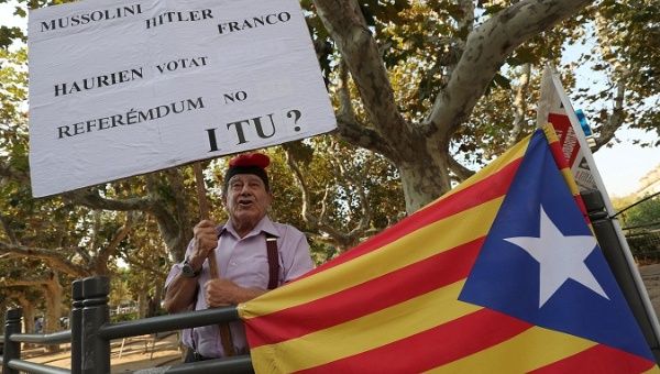 A pro-independence supporter raises up a placard in front of the Catalan regional parliament in Barcelona, Spain, Sept. 6, 2017.
