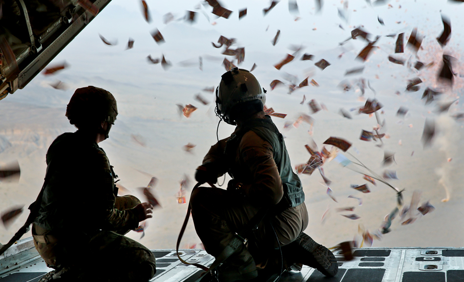 A U.S. Army psychological specialist with and a U.S. Marine Corps load master watch leaflets fall off of a KC-130 Super Hercules over Afghanistan. (FILE)