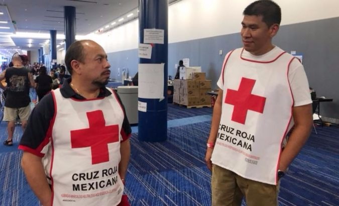 Marco Franco (L), deputy director of Mexican Red Cross disaster relief, talks with Gustavo Santillan as part of a group of Mexican Red Cross volunteers.