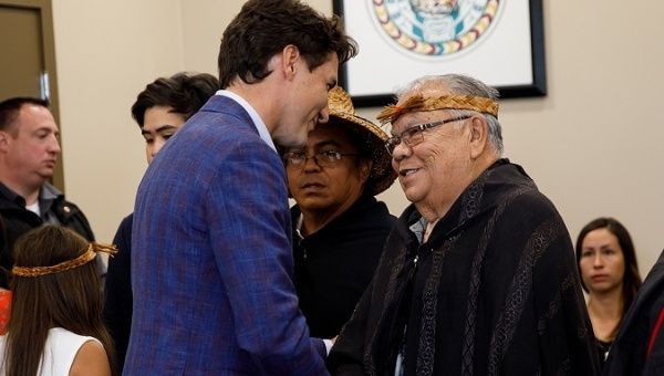 Canadian Prime Minister Justin Trudeau (L) meets a First Nations representative (R). 